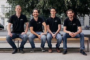 Die vier Gründer der Space StartUps ARTI sitzen auf einer Bank und lächeln in die Kamera. 