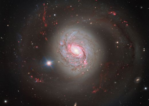 Die spiralförmige Galaxie erinnert an einen rosafarbenen Donut