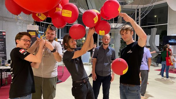 Das Team hält Luftballons in den Händen.