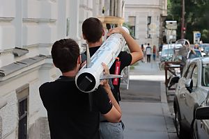 Zwei Männer tragen die Rakete auf der Straße.