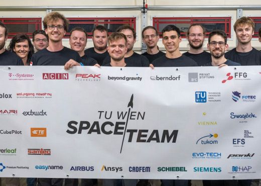 Gruppenfoto des TU Wien Space Team mit einem Transparent, das alle Sponsoren und Unterstützer auflistet
