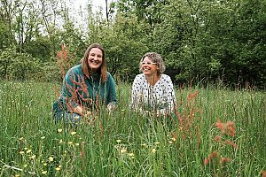 Petra Miletich und Manuela Hirschmugl hocken in der Wiese