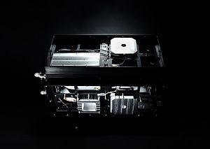 Offenes, würfelförmiges Satellitenmodul mit sichtbaren Elektronikkomponenten und Verkabelung vor schwarzem Hintergrund.