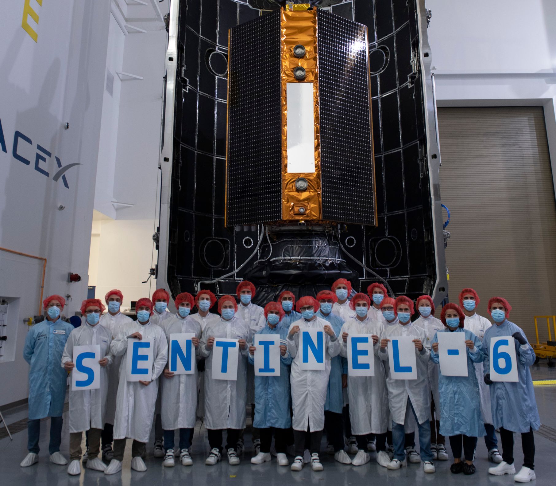 Last group picture for the launch campaign team before the Copernicus Sentinel-6 Michael Freilich satellite is sealed from view within the two half-shells of its Falcon 9 rocket fairing.